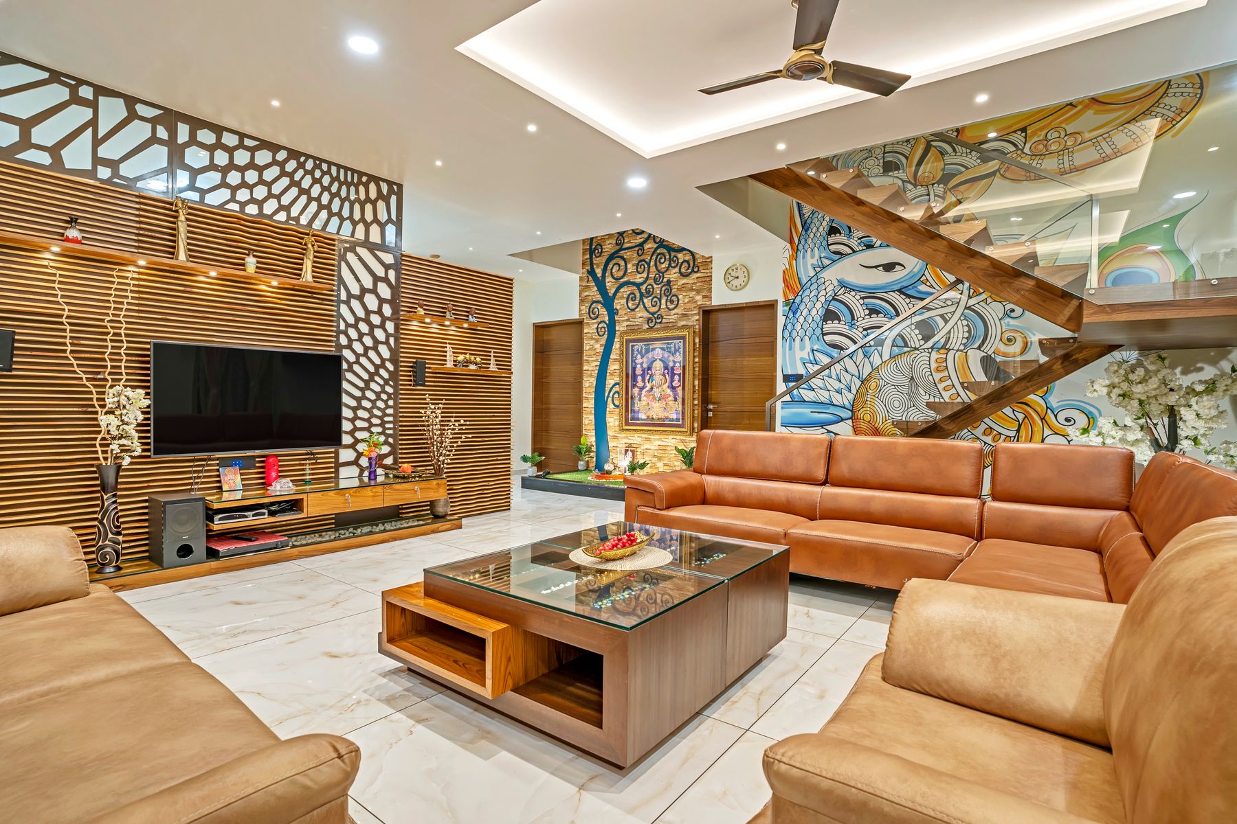 A warm, elegantly furnished living room in a Mumbai residence designed with brass and teak accents
