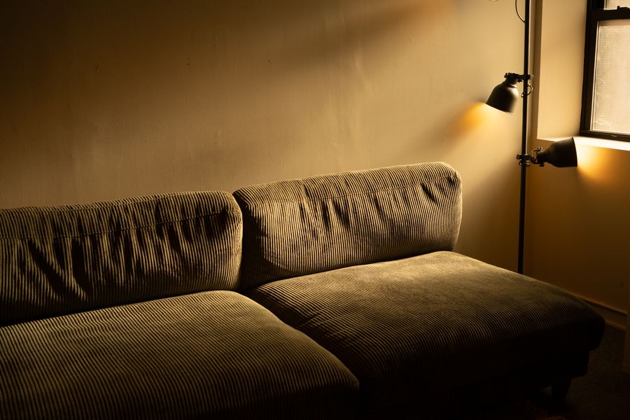 A corduroy sofa in warm evening lamplight in a completed living room
