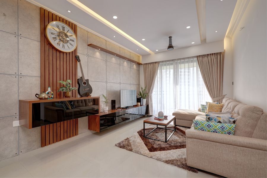 A fully designed living room in warm tones with layered lighting, Kochi