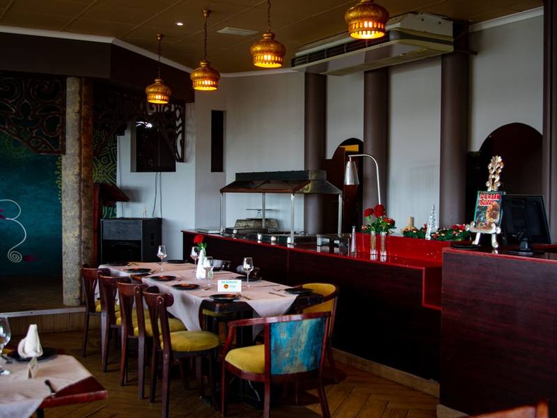 Elegant restaurant dining room with wooden tables and hanging lamps