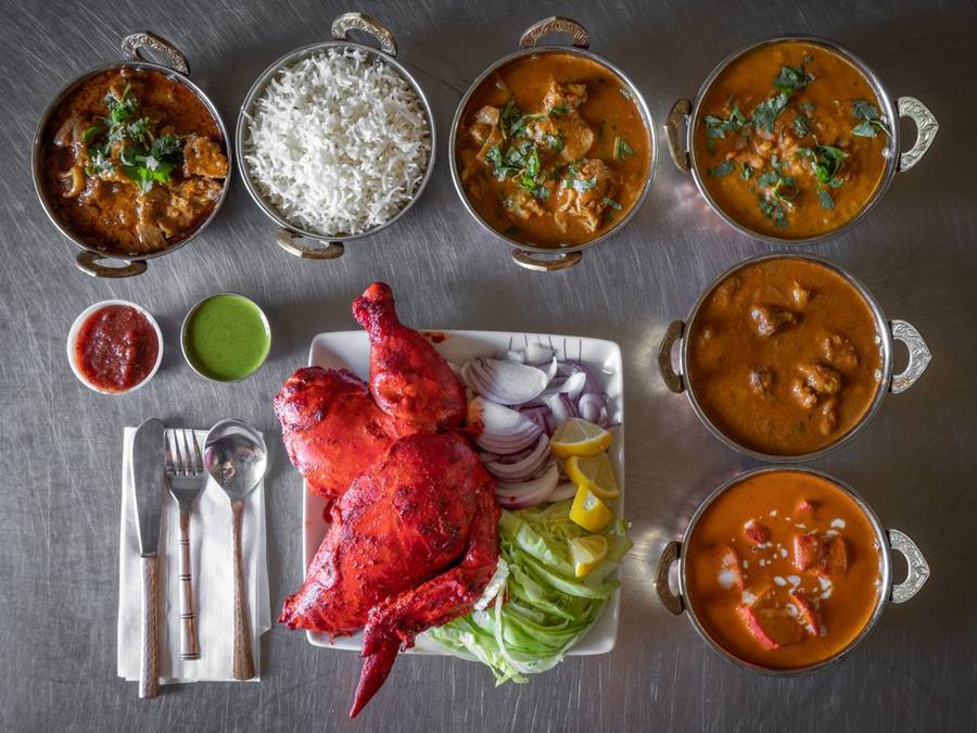 Overhead view of a royal thali platter with tandoori chicken and curries