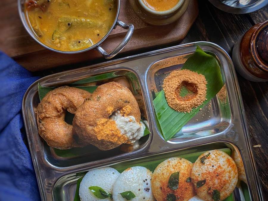 Steel tiffin tray with idli, vada, sambar and chutneys