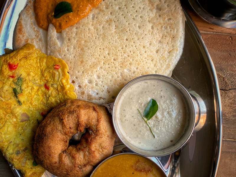 South Indian meals on a steel plate with vada, sambar and chutney