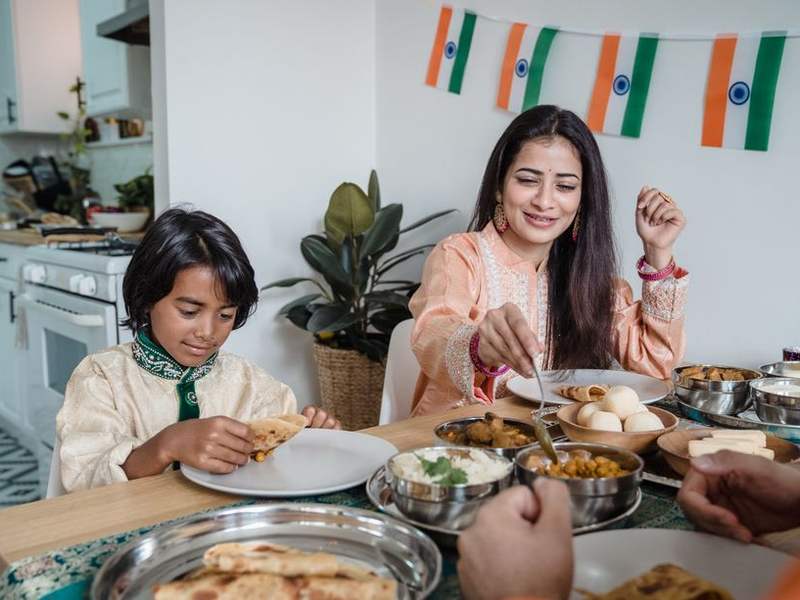 Indian mother and child sharing a meal at a table
