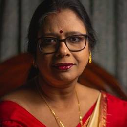 Indian woman with glasses in a red saree smiling