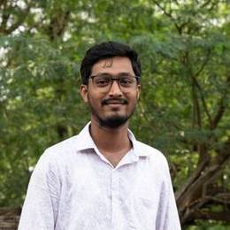 Young Indian man with glasses in a white shirt outdoors