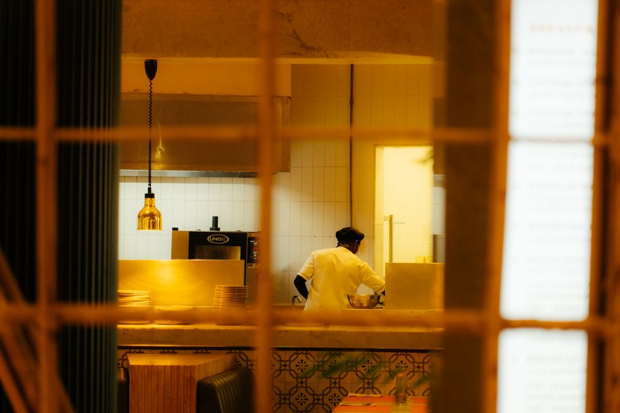 A chef preparing food in a warm restaurant kitchen at night
