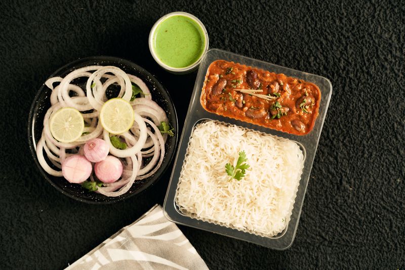A home-style Indian meal of rajma curry, basmati rice and salad with green chutney