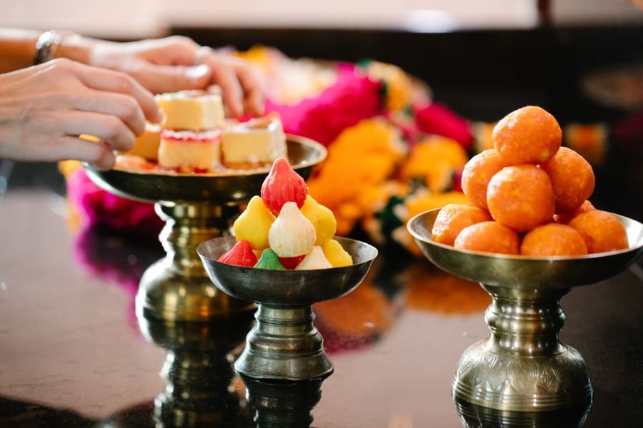 Colourful Indian sweets arranged on ornate brass platters