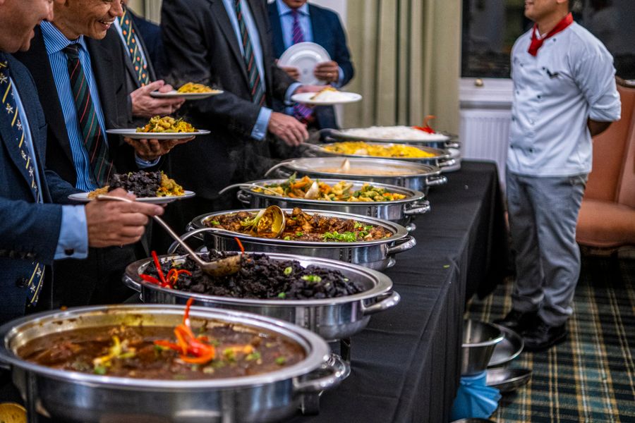 Professionals serving themselves from a corporate buffet lunch spread