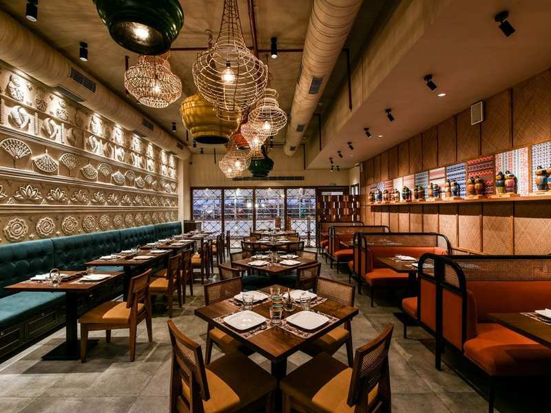 Restaurant dining room with jaali panels and brass lamps