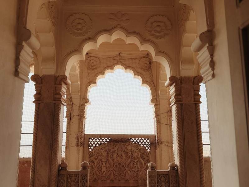 Carved sandstone Mughal arches opening onto a courtyard