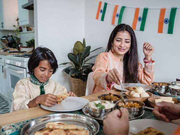 Indian mother and child sharing a meal at the table