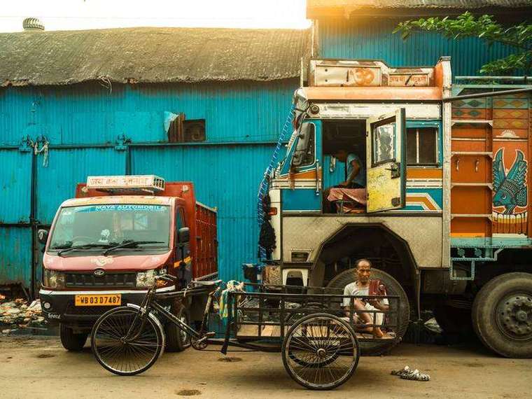 Hand-painted Indian truck parked outside a blue wall
