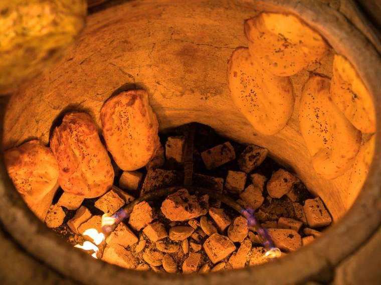 Glowing coals inside a clay tandoor