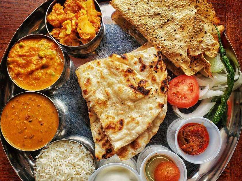 Steel thali with naan, paneer curry, dal, rice and chutneys