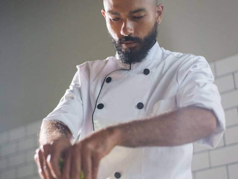 Chef working at a counter under warm light in an open kitchen