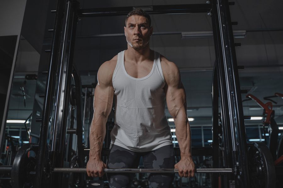 A lifter grinding through a heavy barbell press in a dark gym