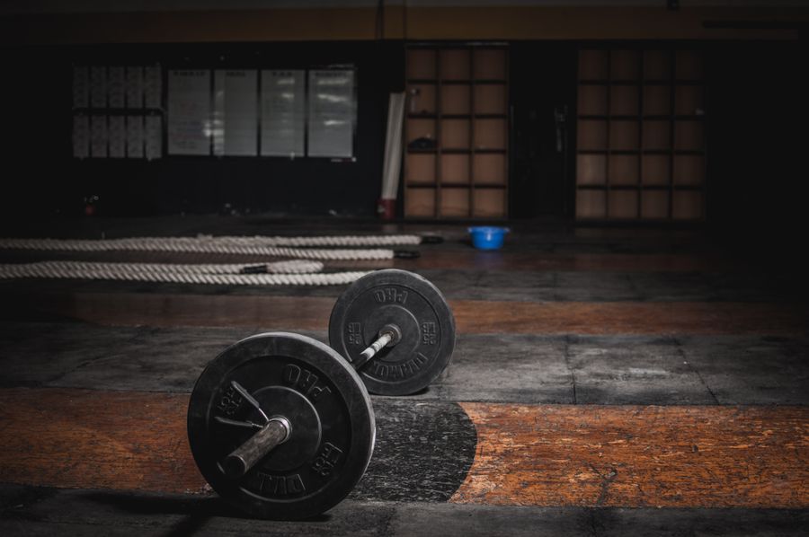 A loaded barbell waiting on the dim training floor