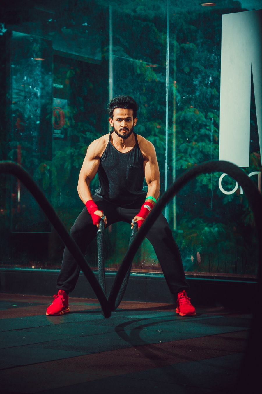 An athlete slamming battle ropes mid-workout