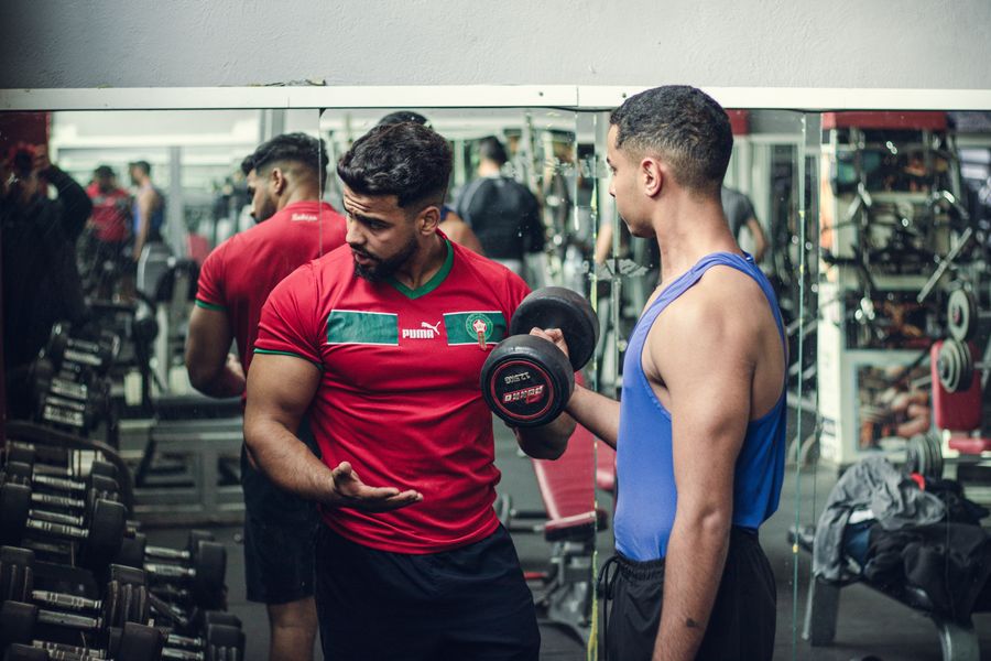 A FORGE coach guiding a client through a weighted movement