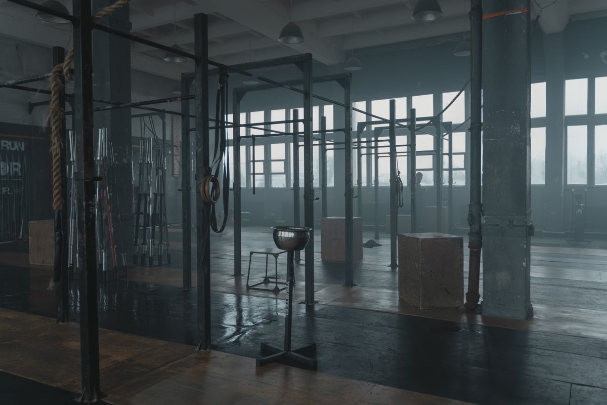The FORGE training floor — a moody industrial gym with pull-up rigs and ropes