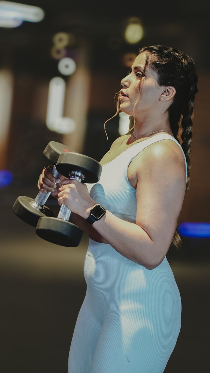 Nandini Rao, Circuits and Conditioning Coach, mid-workout with dumbbells