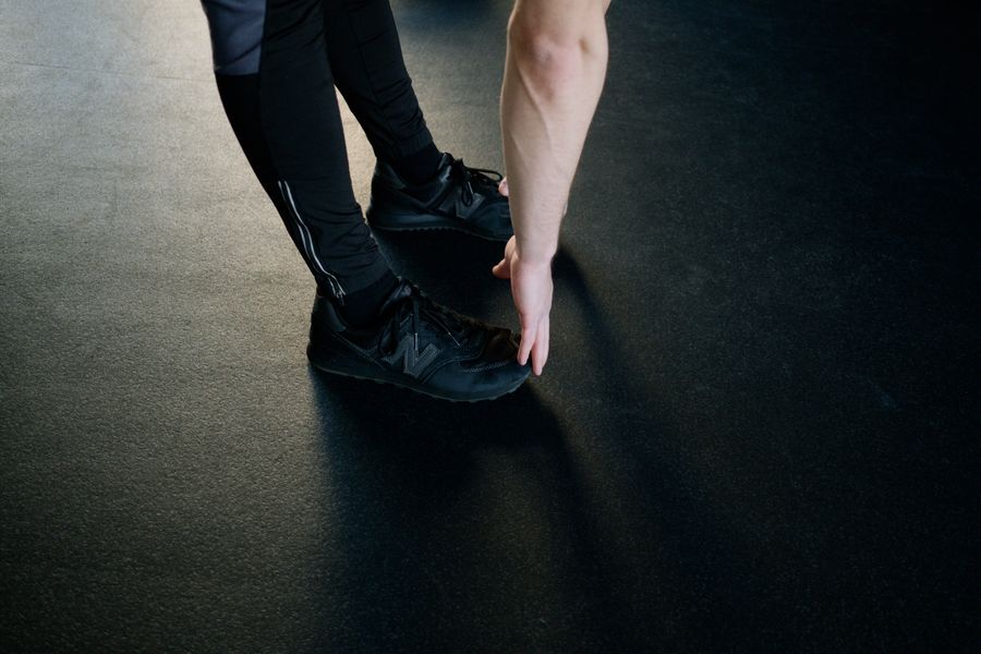 An athlete deep in a hamstring stretch on the gym floor