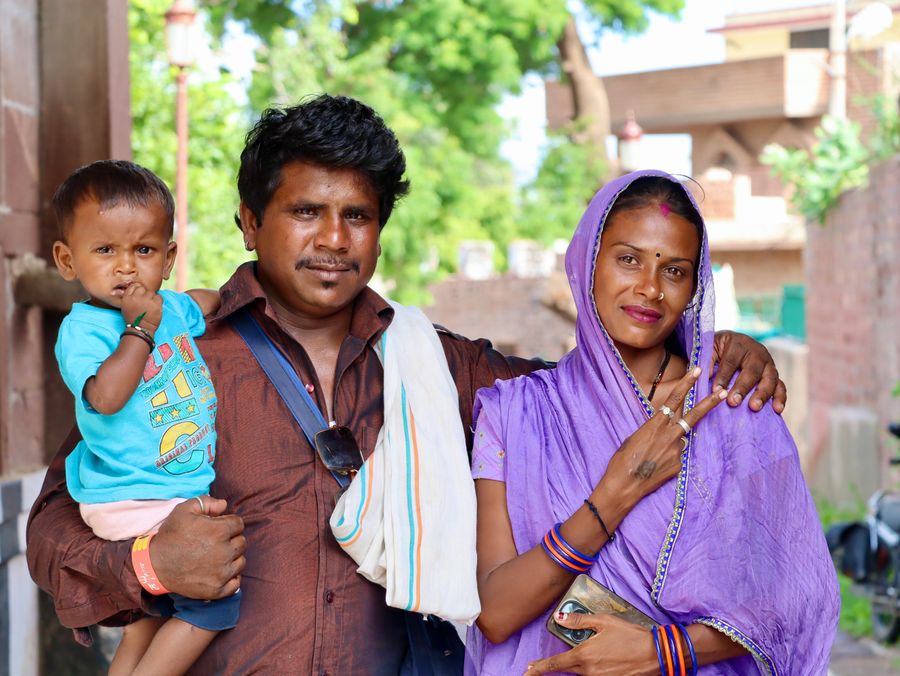 A cheerful Indian family embracing each other outdoors on a sunny day