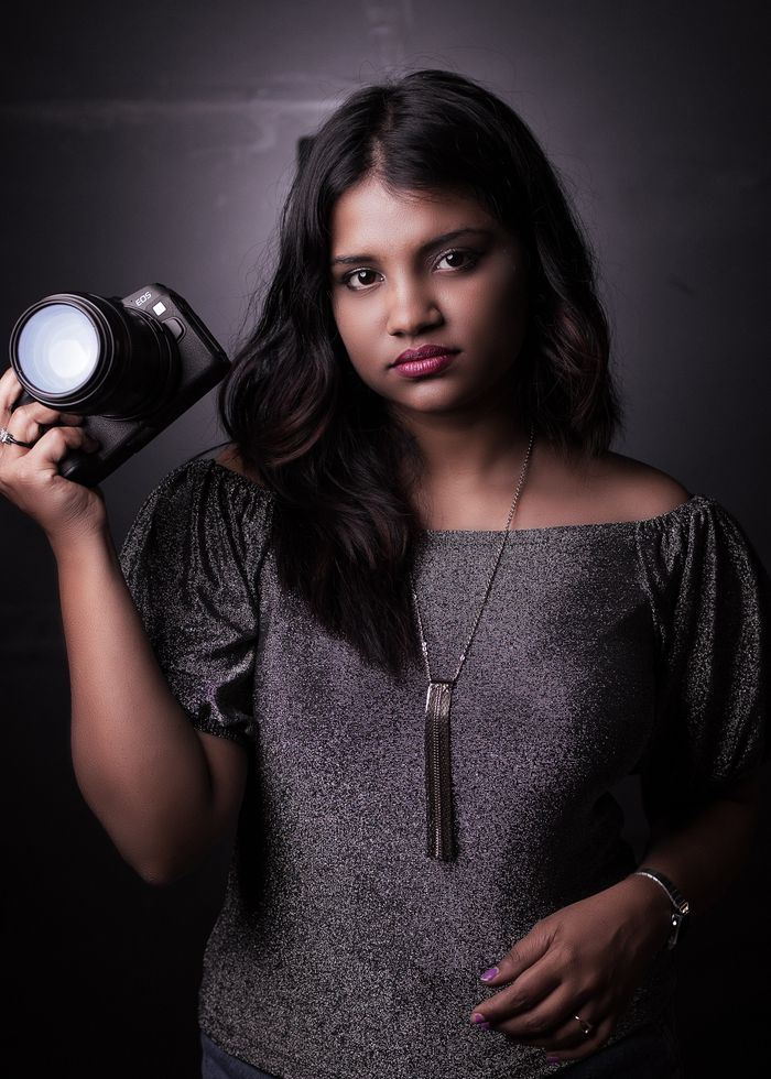 Ishita Vyas, Senior Editor and Colourist, holding a camera in elegant low light