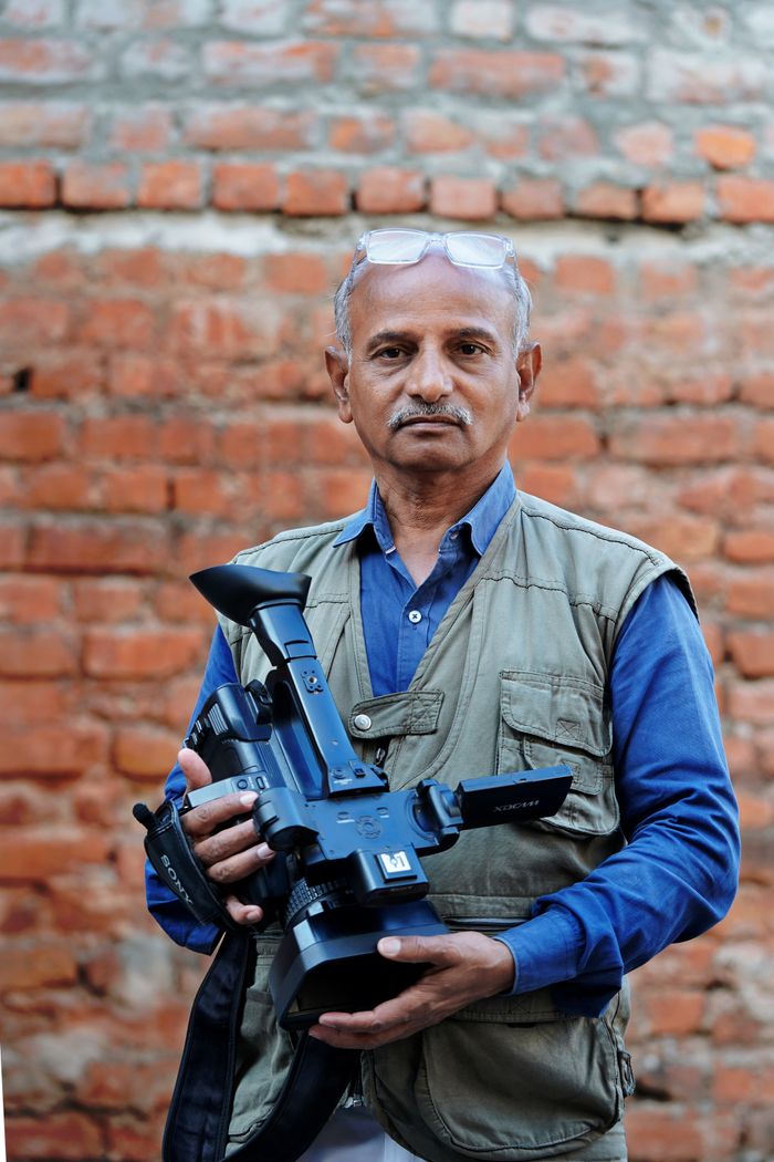 Kabir Sheikh, Cinematographer, carrying his camera rig against a brick wall