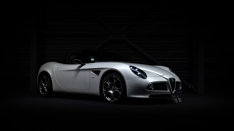 A white sports car under low light in the Glosswerk delivery bay