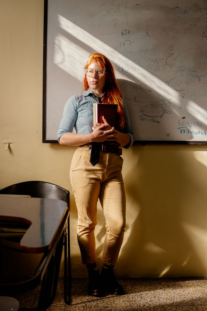 Kavya Sharma, Lead Early Educator, holding a storybook in a sunlit classroom