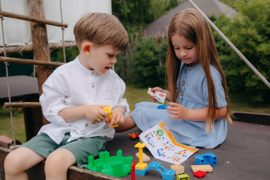 Two toddlers playing with colourful building blocks in the playgroup room