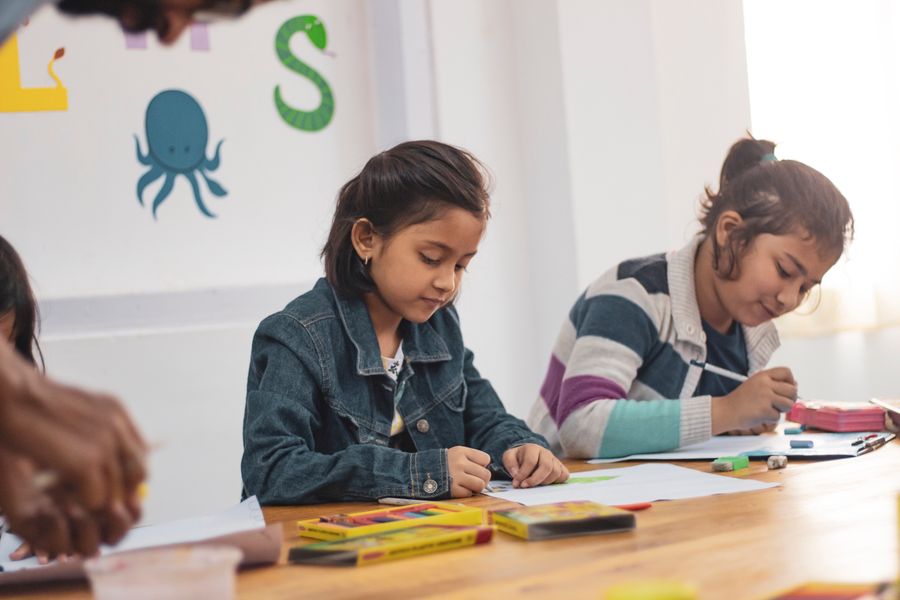 Young girls drawing and colouring together in a Gubbara classroom