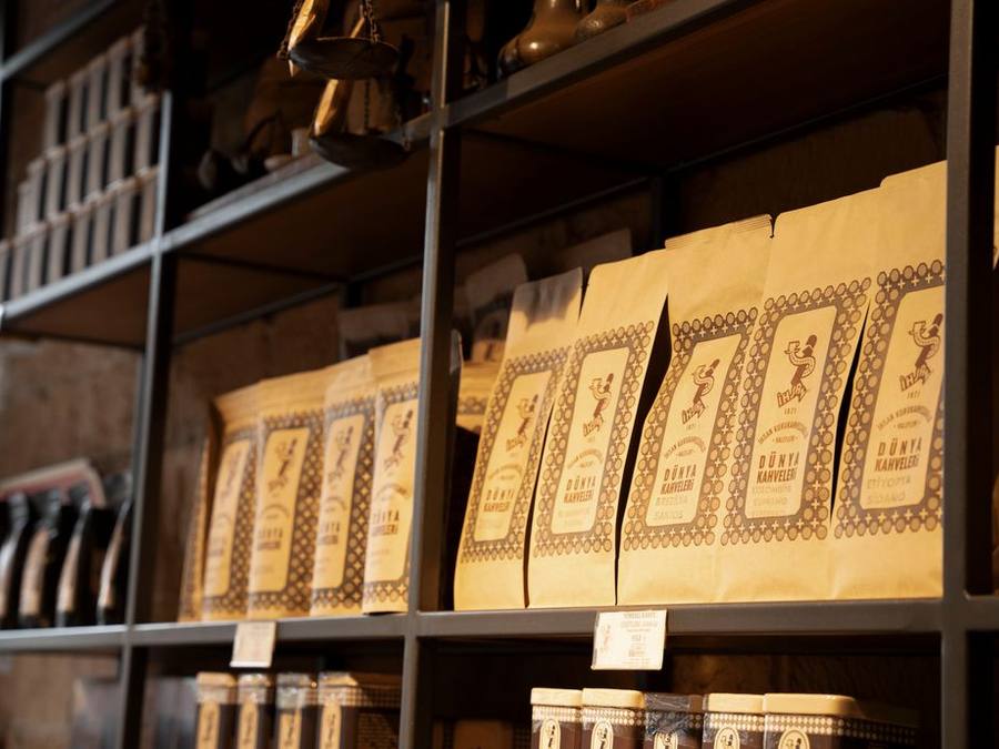 Bags of coffee beans lined up on wooden shelves