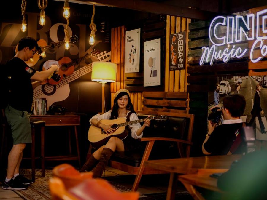 Guitarist performing to a small audience inside a café