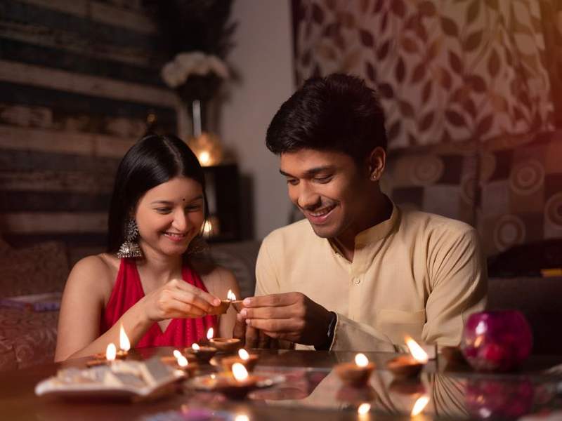 Indian couple sharing a candlelit dinner at a wooden table