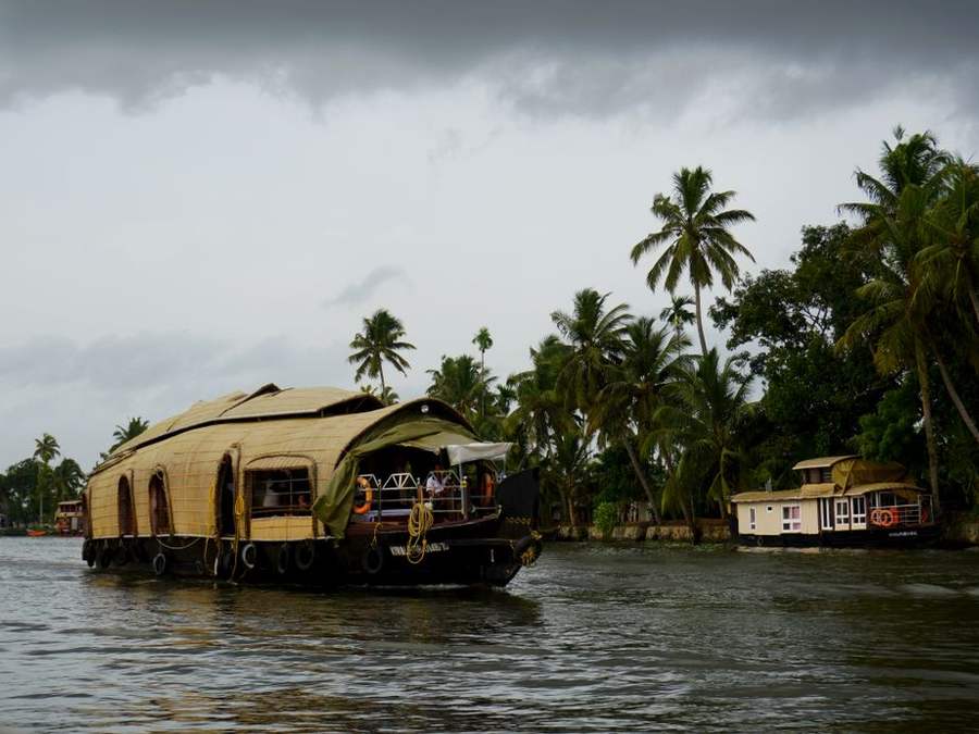 Traditional Kerala houseboat on the backwaters under a grey evening sky