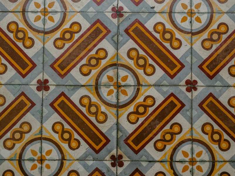 Hand-made athangudi floor tiles in mustard, teal and rust patterns