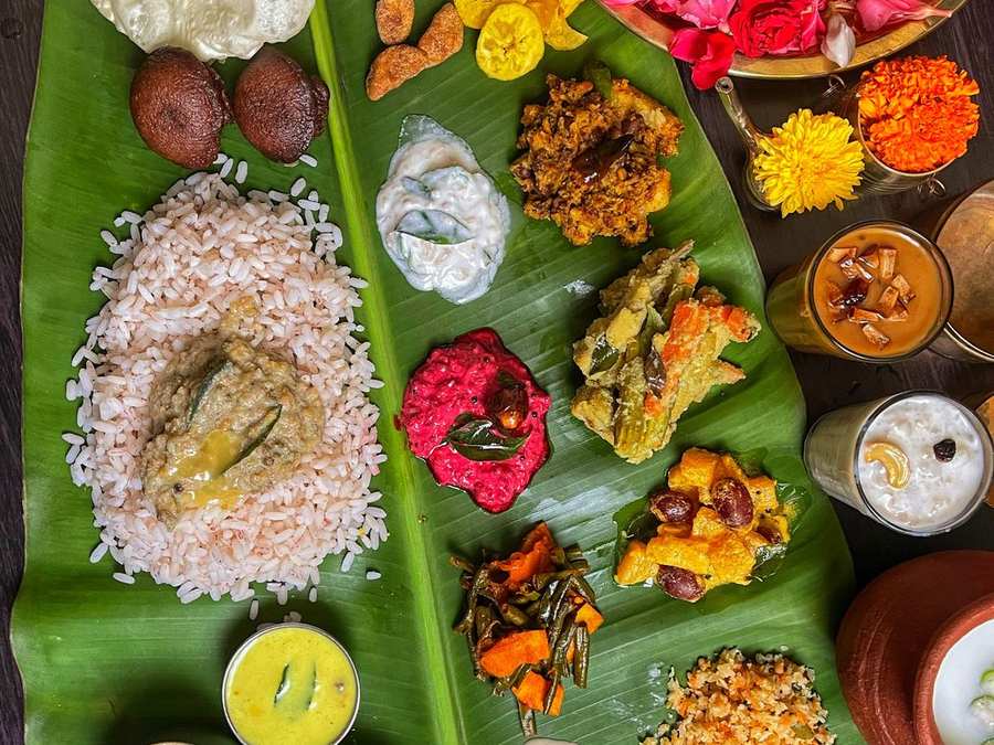Elaborate banana leaf feast with many small dishes and flowers