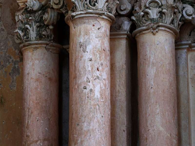 Weathered stone pillars with carved capitals in an old Chettinad mansion