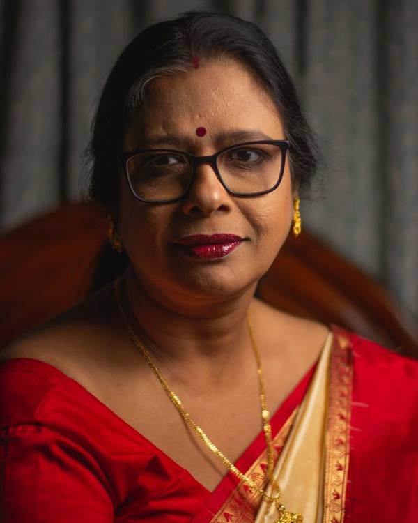 Indian woman with glasses wearing a red saree, portrait