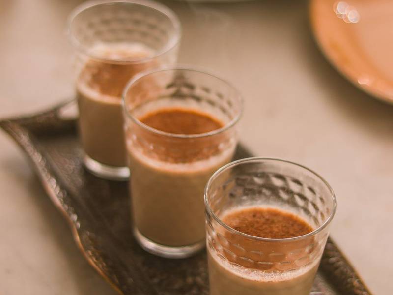 Three glasses of chai on a metal tray