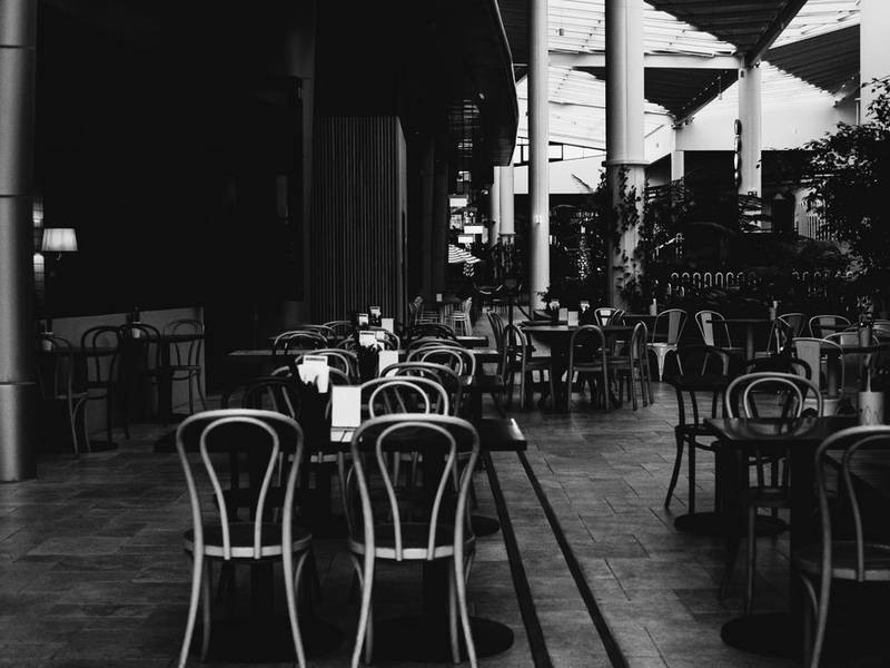 Black-and-white view of empty bentwood chairs in an old café