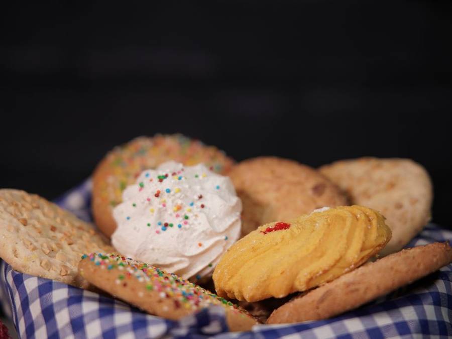 Butter biscuits and cookies in a basket lined with a blue checkered cloth