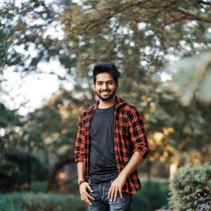 Young Indian man in a checked shirt smiling outdoors