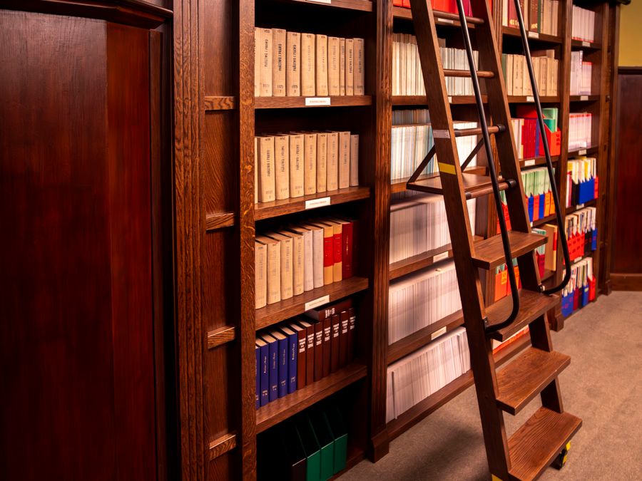 Tall wooden shelves of bound volumes in the chambers library
