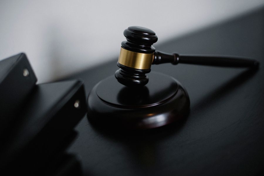 A ceremonial gavel with gold detailing resting on a judge's table