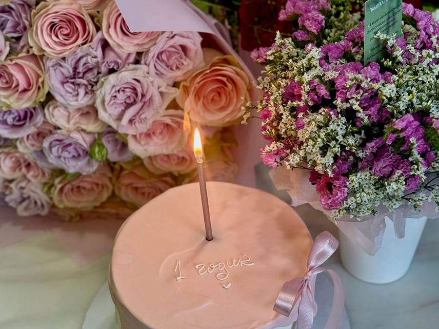 Pink celebration cake with fresh flowers and candles